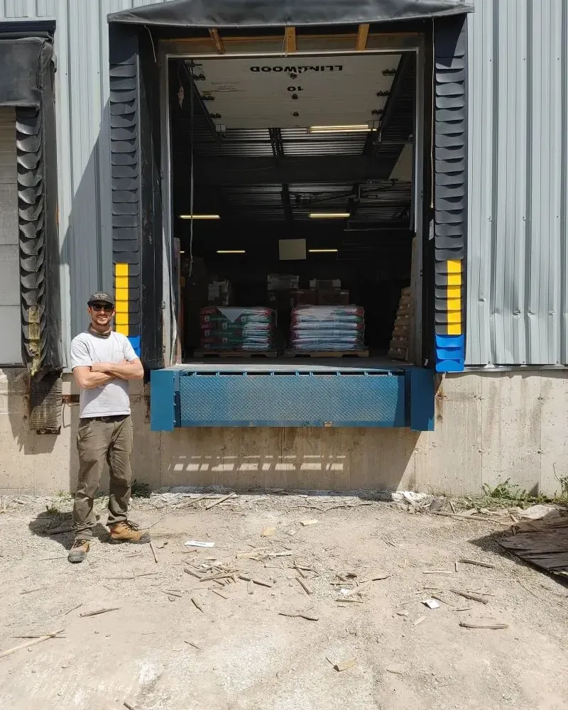 Loading dock with shelter, bumpers, and dock leveler