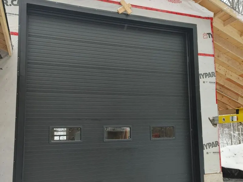 Large black commercial sectional overhead door on a new build