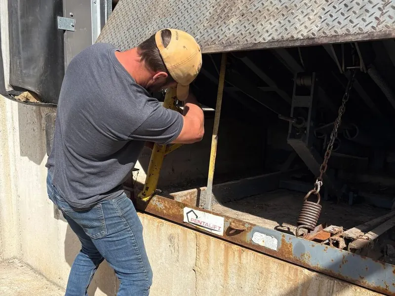 Technician servicing overhead door and dock hardware